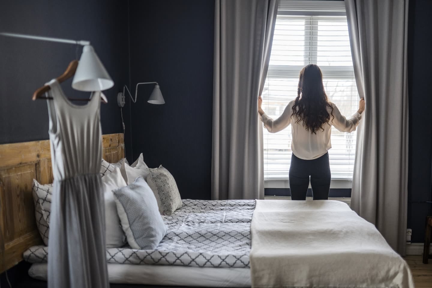 View of a woman standing in a hotel room in boutique hotel Lillan Hotel & Kök in Tampere.